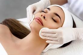 A woman enjoying a facial treatment at a spa, with soothing products applied to her face for relaxation and rejuvenation.